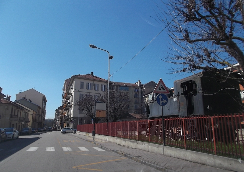 Veduta della cancellata di separazione del cortile della Scuola elementare Galileo Ferraris di Asti dal trafficato corso adiacente.