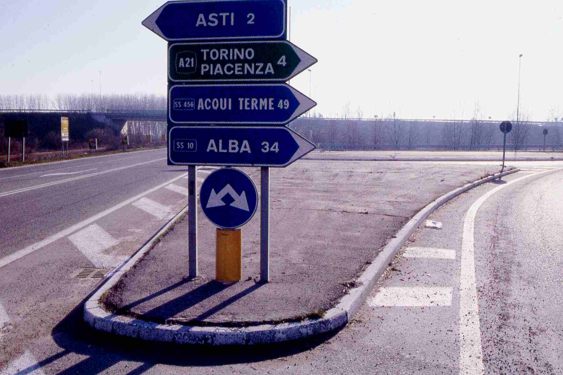 Intersezione stradale tradizionale con aiuole prive di sistemazione a verde e di scarso valore paesaggistico (Corso Casale - Asti). 