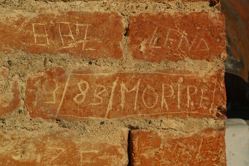 Frasi e disegni incisi sui muri della Cittadella di Alessandria. 1983.  9/83/MORIRE.