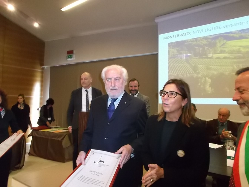 Consegna dell Omaggio "Langhe-Roero e Monferrato: onde di bellezza e geometrie coltive nei paesaggi e nei paesi del vino" da parte del Senatore Tommaso Zanoletti alla Dott.ssa Tina Guiducci, in rappresentanza del Dott. Piero Rossi Cairo (Società Agricola La Raia) e al Sindaco di Novi Ligure, Dott. Rocchino Muliere e all Assessore all Urbanistica, Arch. Maria Rosa Serra.