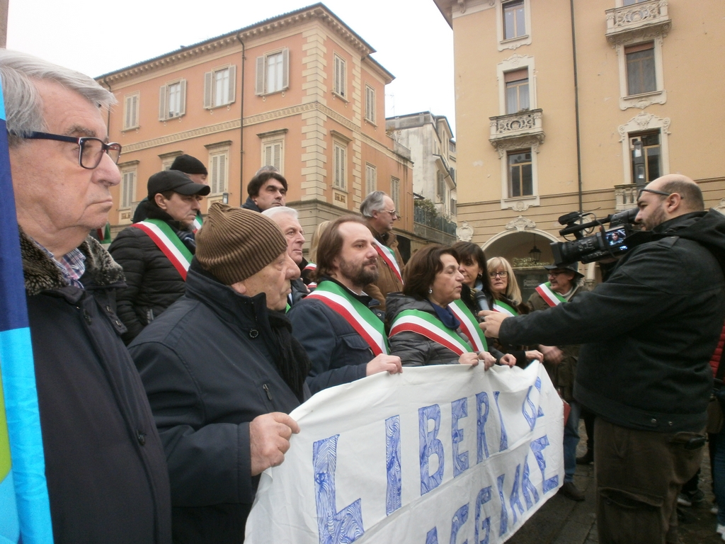 Riflessione sul tema della Veduta del numeroso ed interessato pubblico in Piazza Mazzini a Casale Monferrato a sostegno della riattivazione delle Linee ferroviarie Casale Monferrato - Vercelli; Casale Monferrato - Mortara e Casale Monferrato - Asti da parte del Sindaco di Casale Monferrato, Dott.ssa Titti Palazzetti.