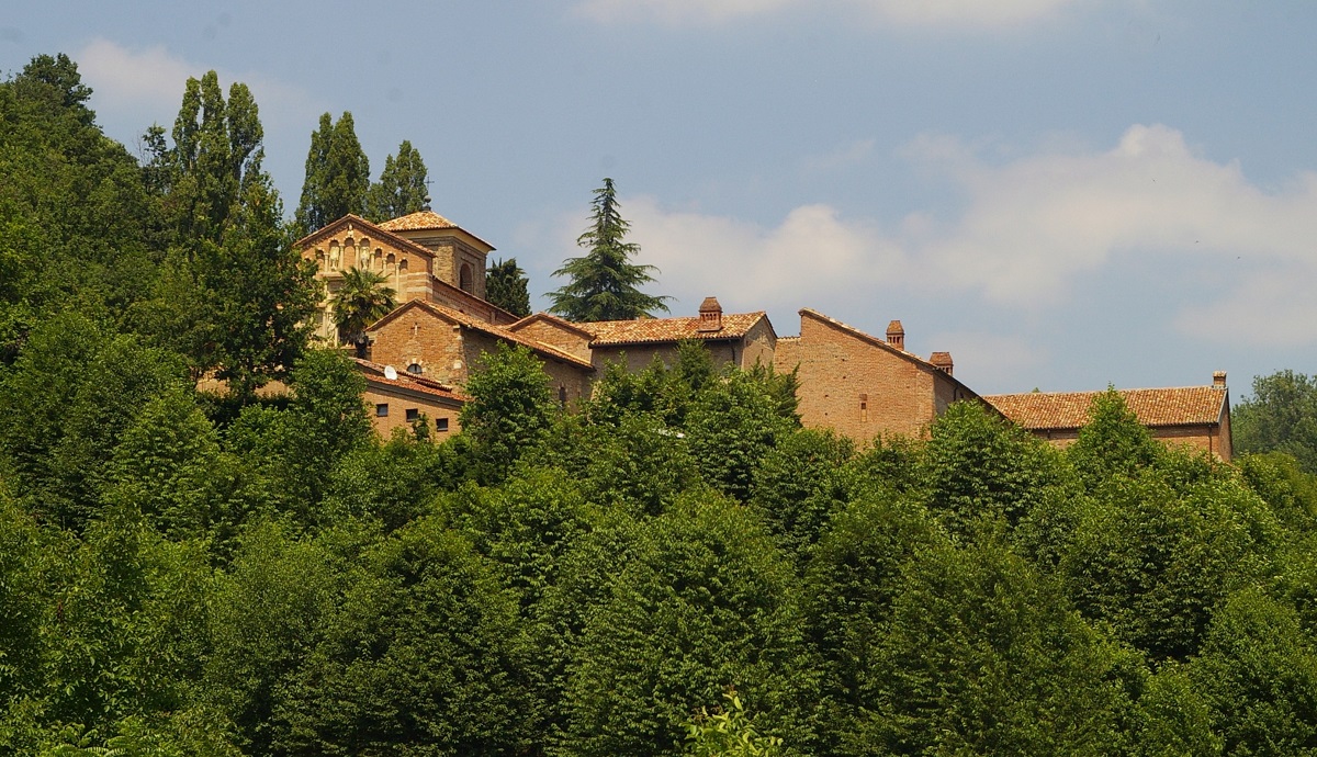 Veduta tra la vegetazione arborea della Canonica di Santa Maria di Vezzolano.