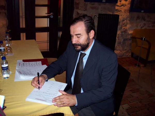   Firma del documento di accettazione della richiesta di inserimento della Canonica di Vezzolano nell'ambito del progetto Transromanica da parte di Marco Devecchi dell'Osservatorio del Paesaggio per il Monferrato e l'Astigiano.