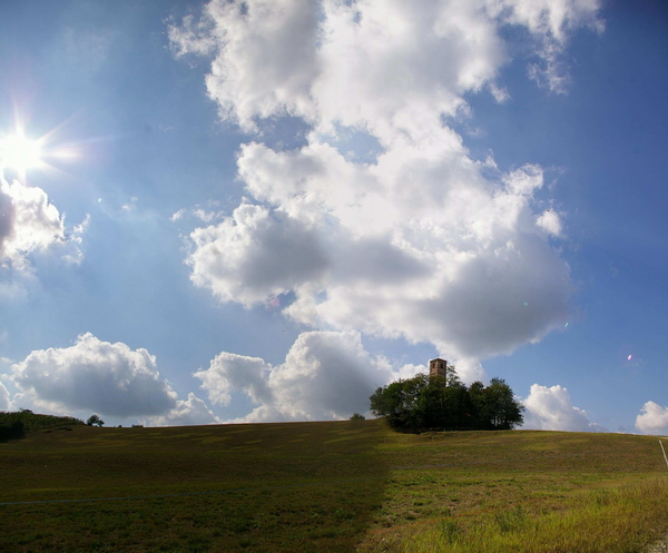 Veduta delle nuvole sulla Chiesa romanica dei Santi Nazario e Celso a Montechiaro d'Asti.