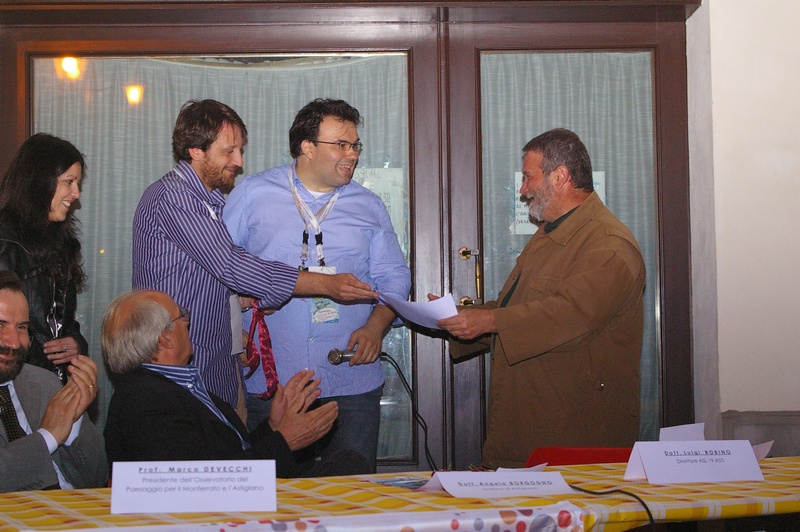 Consegna da parte di Luca Chiusano della Taghetta botanica relativa alla pianta consegnata, quale premio, al Dott. Luigi Robino (Direttore dell'ASL di Asti).